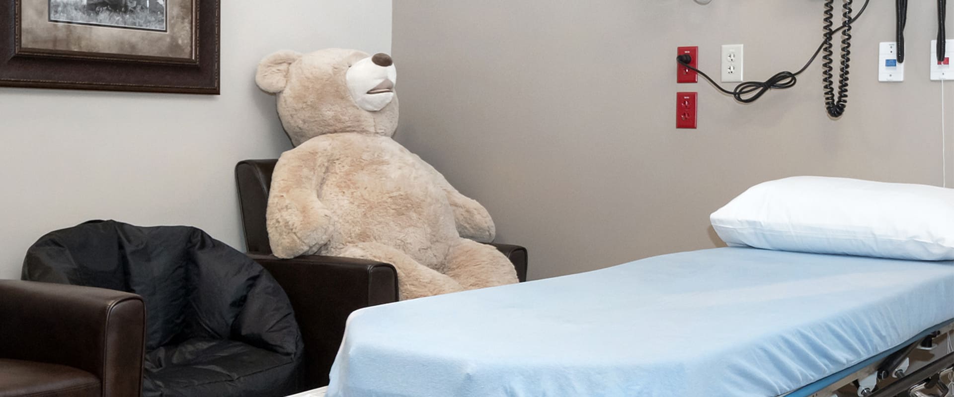 Comforting pediatric care room with large teddy bear at Express ER Temple